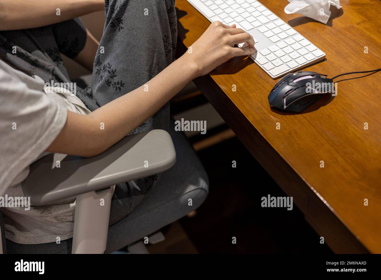 Woman is using a computer with a bad posture Stock Photo