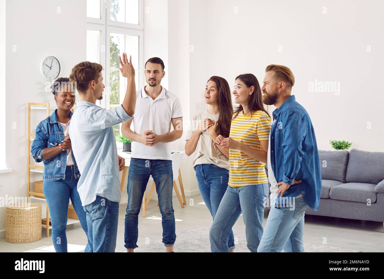 Group of several diverse multiracial friends listening to a young man ...