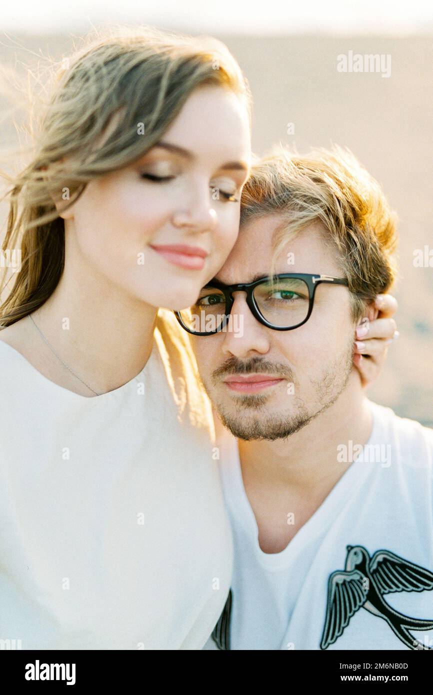 Young woman hugs a man sitting in his arms. Portrait Stock Photo