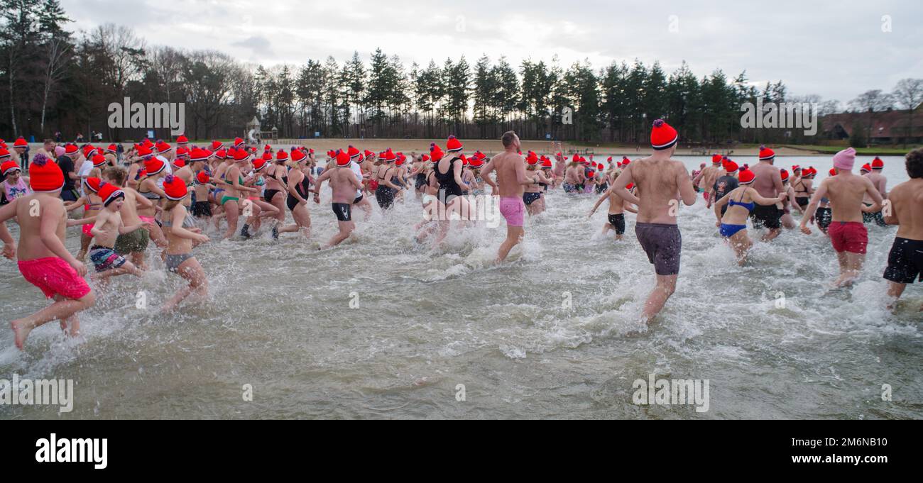 OLDENZAAL, NETHERLANDS - JANUARY 1, 2023: People running into the water at the traditional new years dive Stock Photo