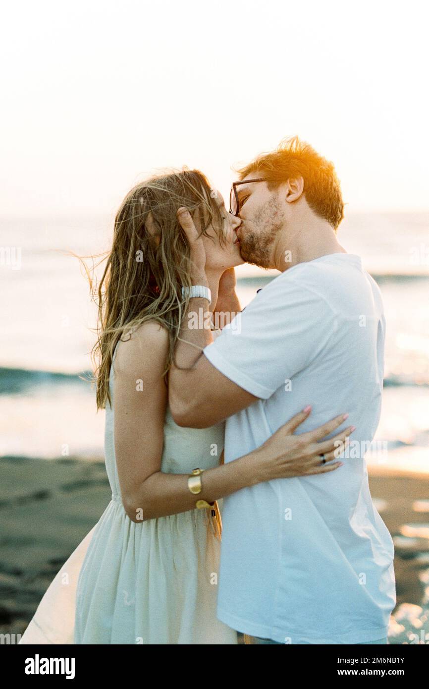Man kissing a woman holding her head in his hands Stock Photo Alamy