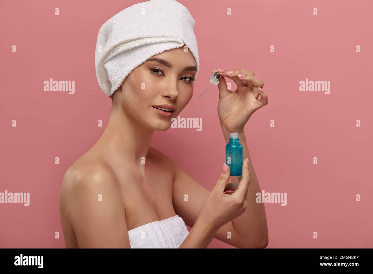 Asian girl in white hair turban using serum, retinol. Stock Photo