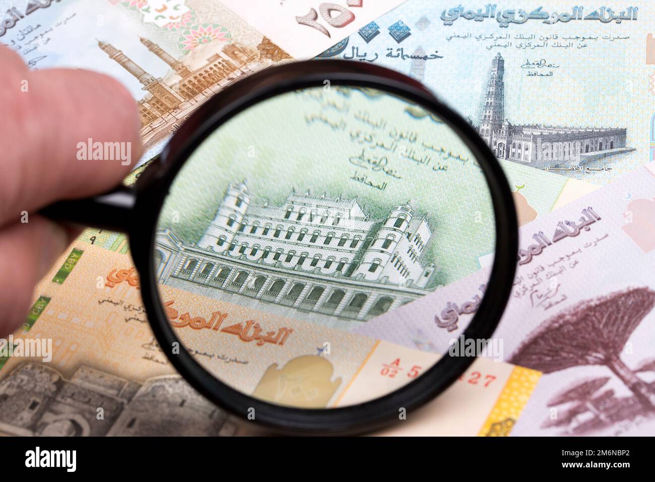 Yemeni rial in a magnifying glass Stock Photo