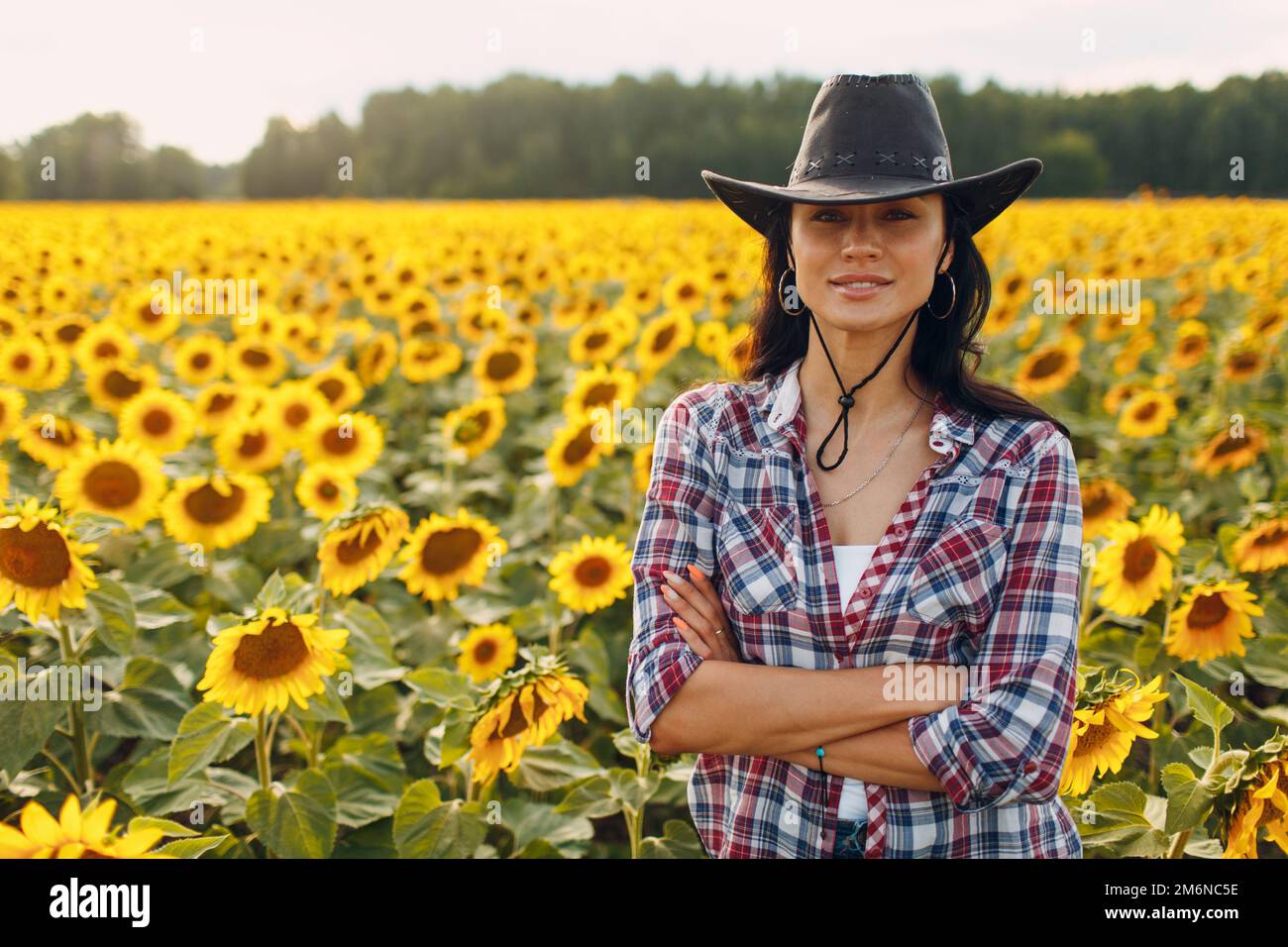 Young woman agronomist wearing cowboy hat, plaid shirt and jeans on