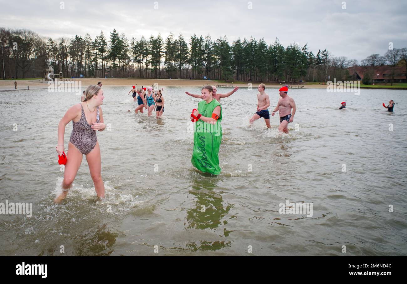 OLDENZAAL, NETHERLANDS - JANUARY 1, 2023: People running into the water at the traditional new years dive Stock Photo
