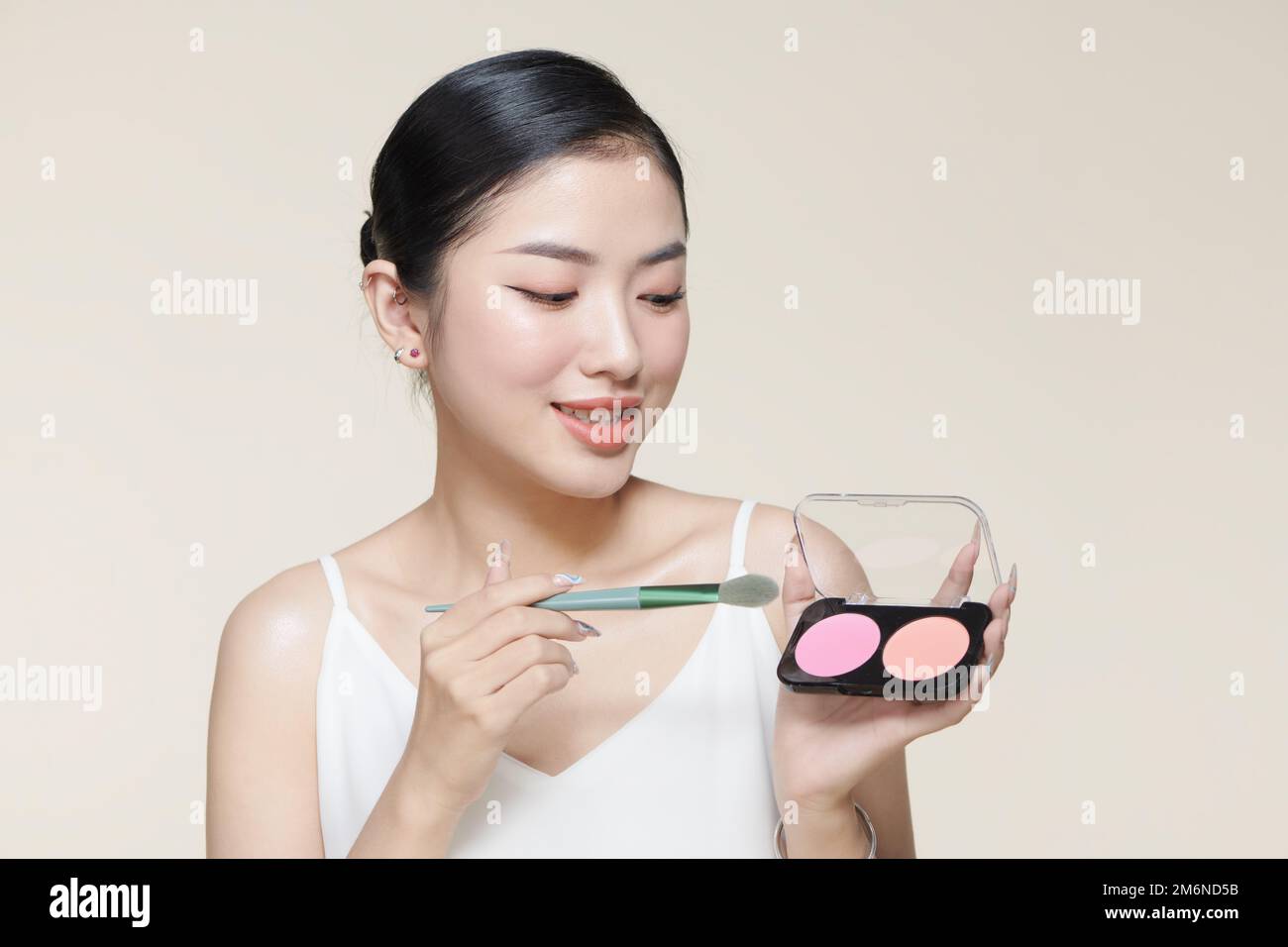 Portrait of stylish trendy modern girl with beaming smile gesturing new quality shadow having palette and brush in hands Stock Photo
