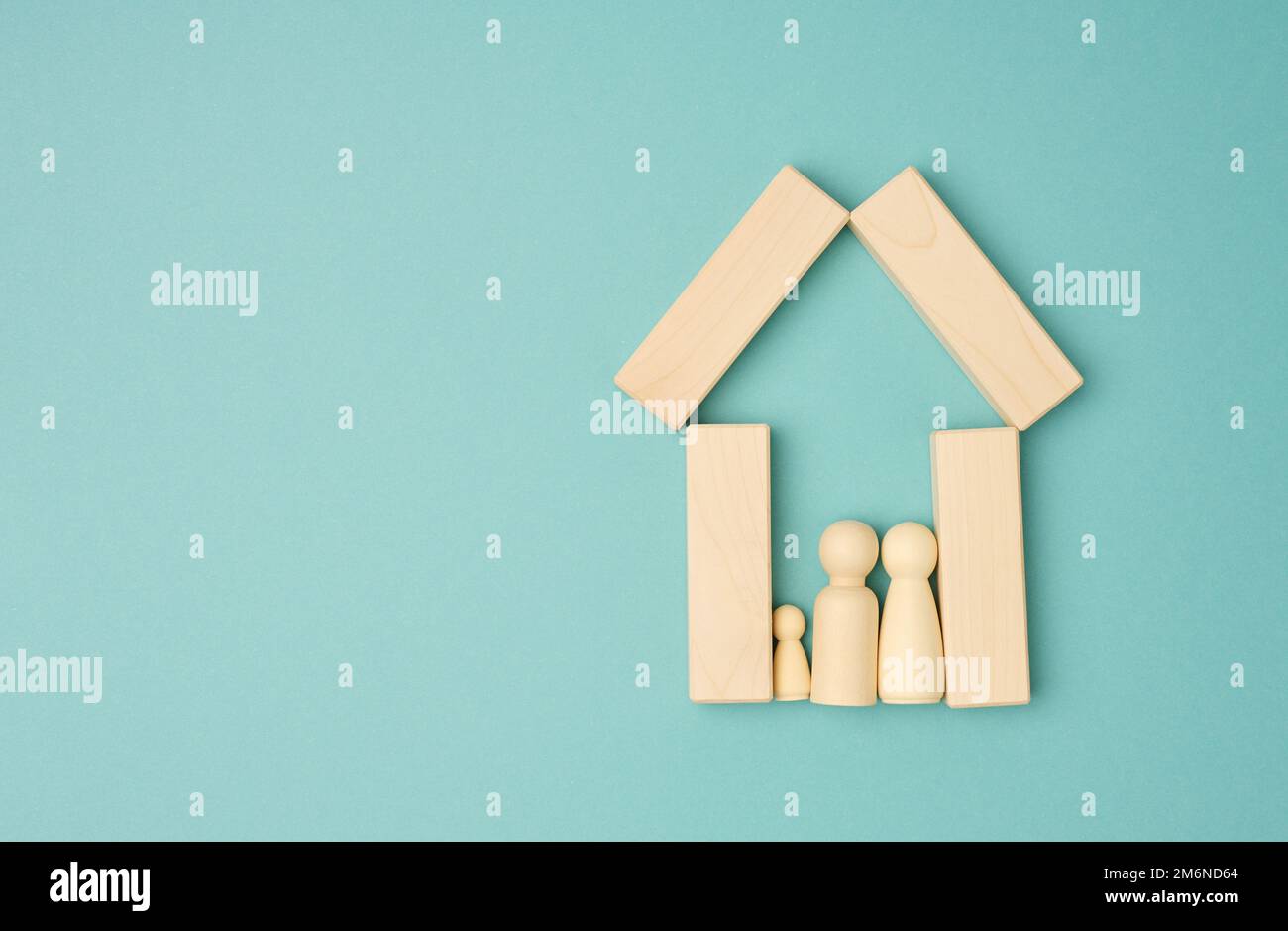 Wooden family figurines, model house on a blue background. Real estate purchase Stock Photo