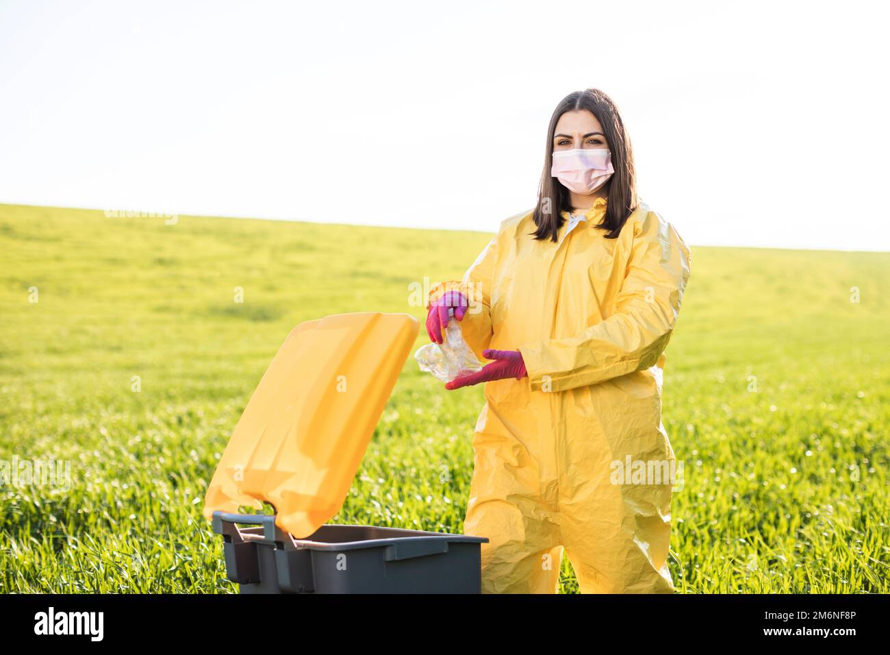 Hand throwing away plastic bottle in nature. Environmental damage by
