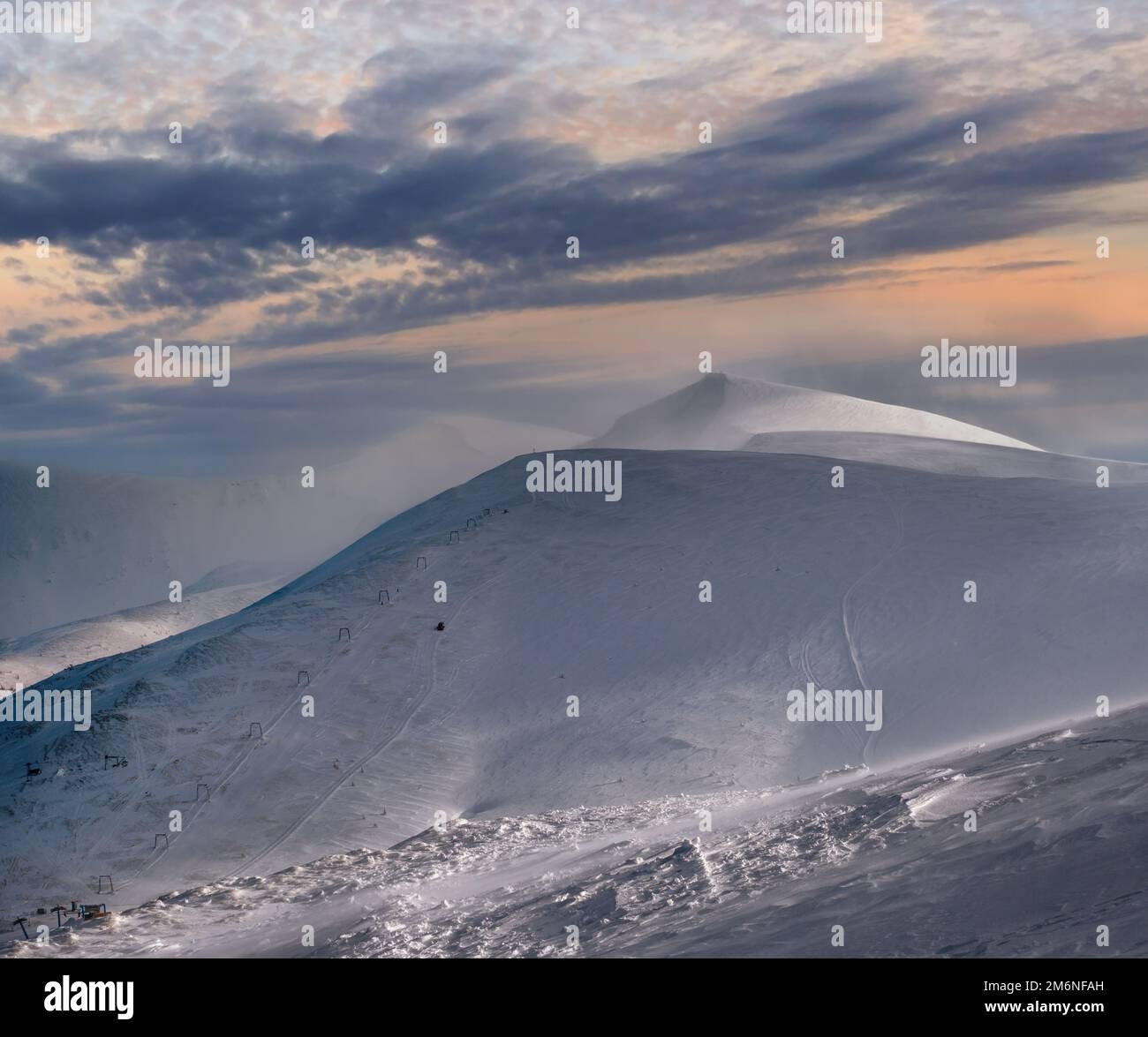 Snow covered mountain slope in last evening sunlight. Magnificent windy