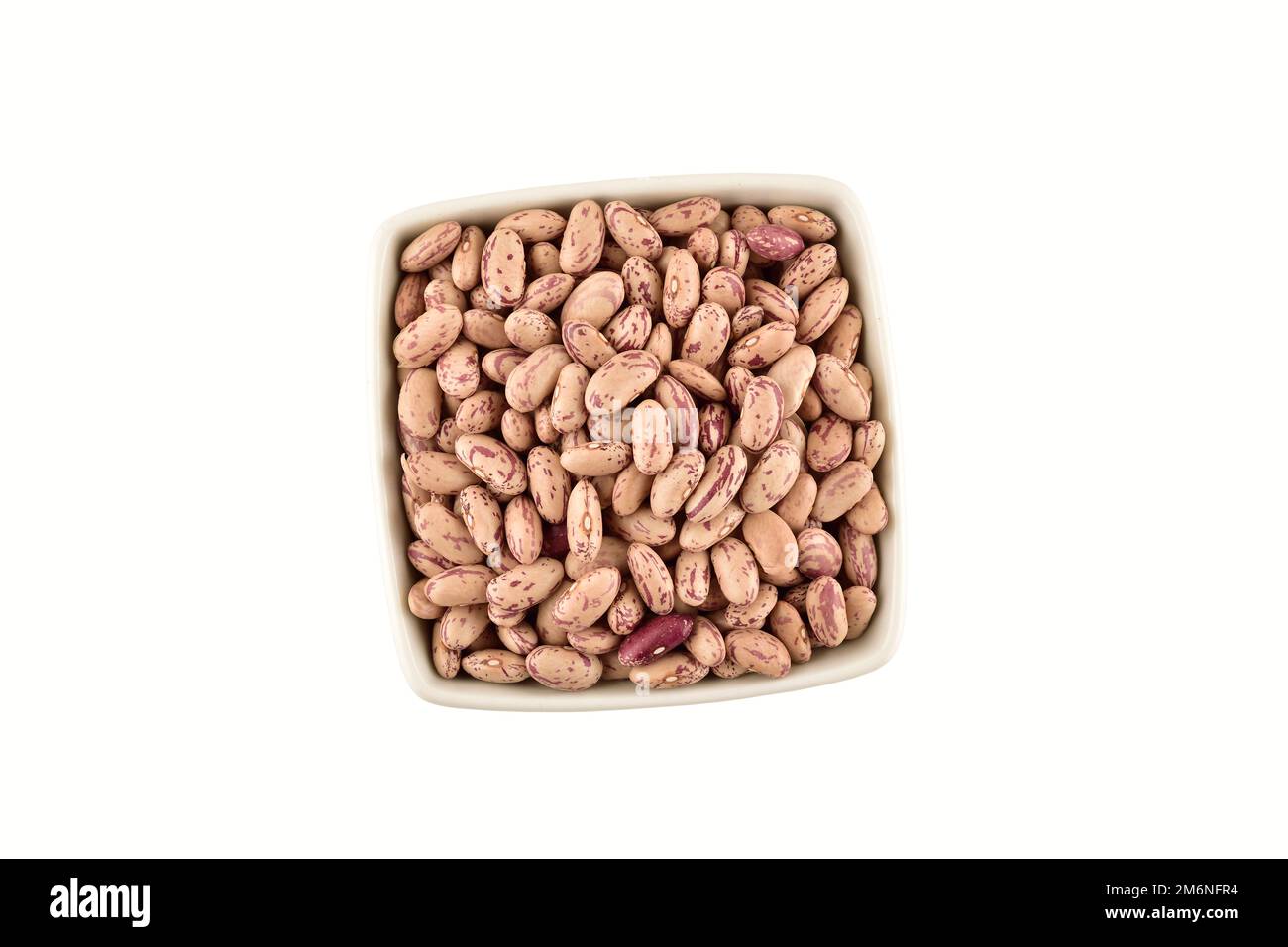 uncooked pinto beans in bowl isolated on white background with clipping