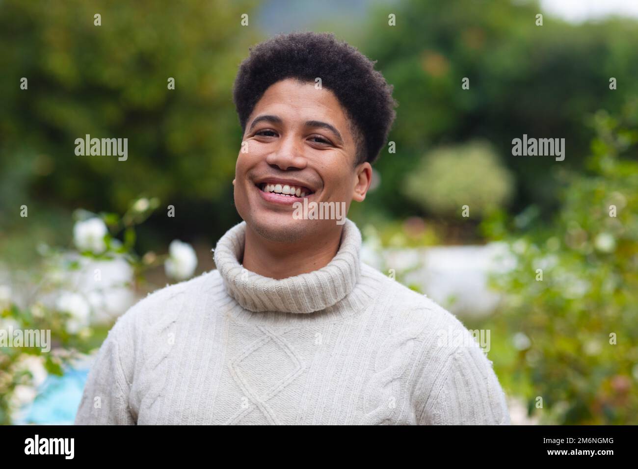 Portrait of happy biracial man smiling to camera in garden Stock Photo