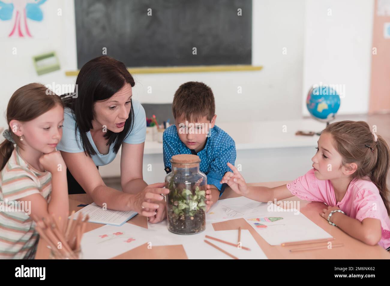 Female Teacher with kids in biology class at elementary school