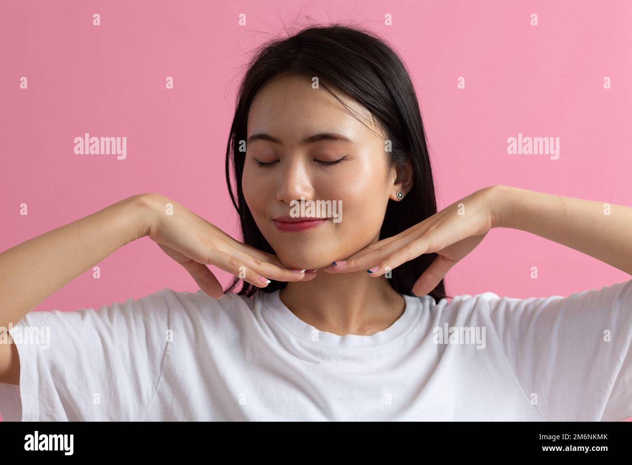 Close up portrait of young asian woman doing facebuilding yoga face gymnastics yoga massage Stock Photo