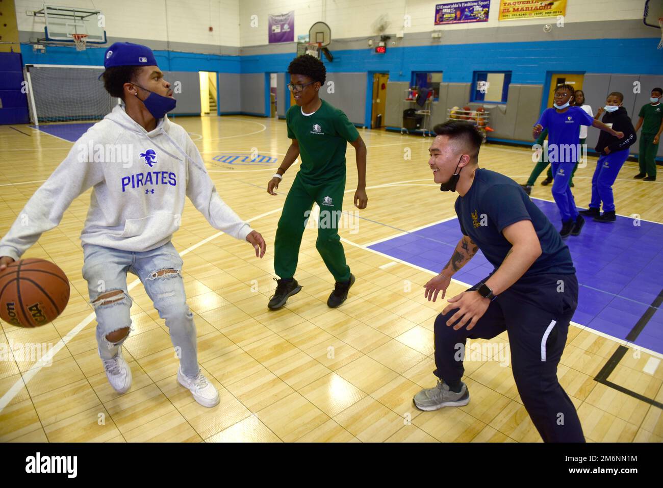 TRENTON, N.J. -- (MAY 3, 2022) U.S. Navy Religious Program Specialist Michael Declaro from San Leandro, Calif, attached to USS Princeton (CG-59) right, plays basketball with kids from the Boys and Girls Club. Declaro led a team of kids as team captain. Declaro's team won the pick-up game, 58-50. Everyone had fun and met new people.   The Navy has done over 20 humanitarian aid and community outreach projects in the greater Trenton, NJ area this week as part of Navy Week Trenton. Navy Week events are held in different cities across the United States year round. They are designed to connect Ameri Stock Photo