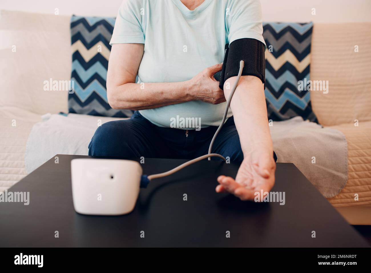 Senior woman taking measures blood pressure at home. Self care of elderly health Stock Photo