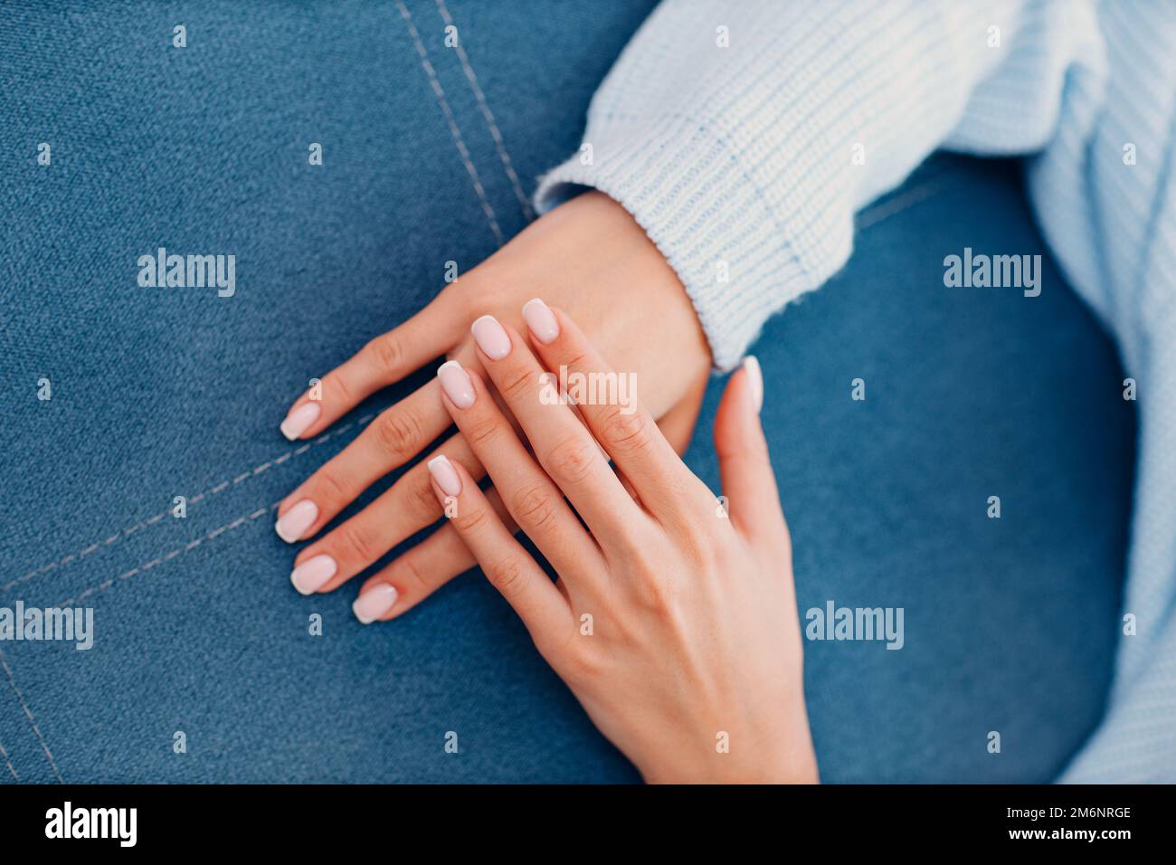 Female hand fingers nails with manicure after nail salon procedure
