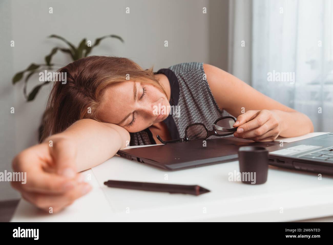 Young woman sleeping in the workplace. Fatigue and overload in office