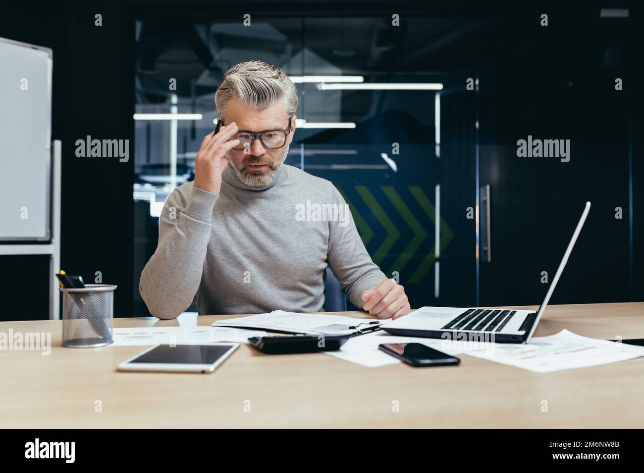 Senior thinking businessman working inside office with laptops, man