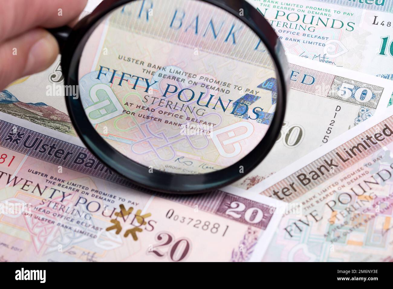 Northern Irish pounds in a magnifying glass Stock Photo