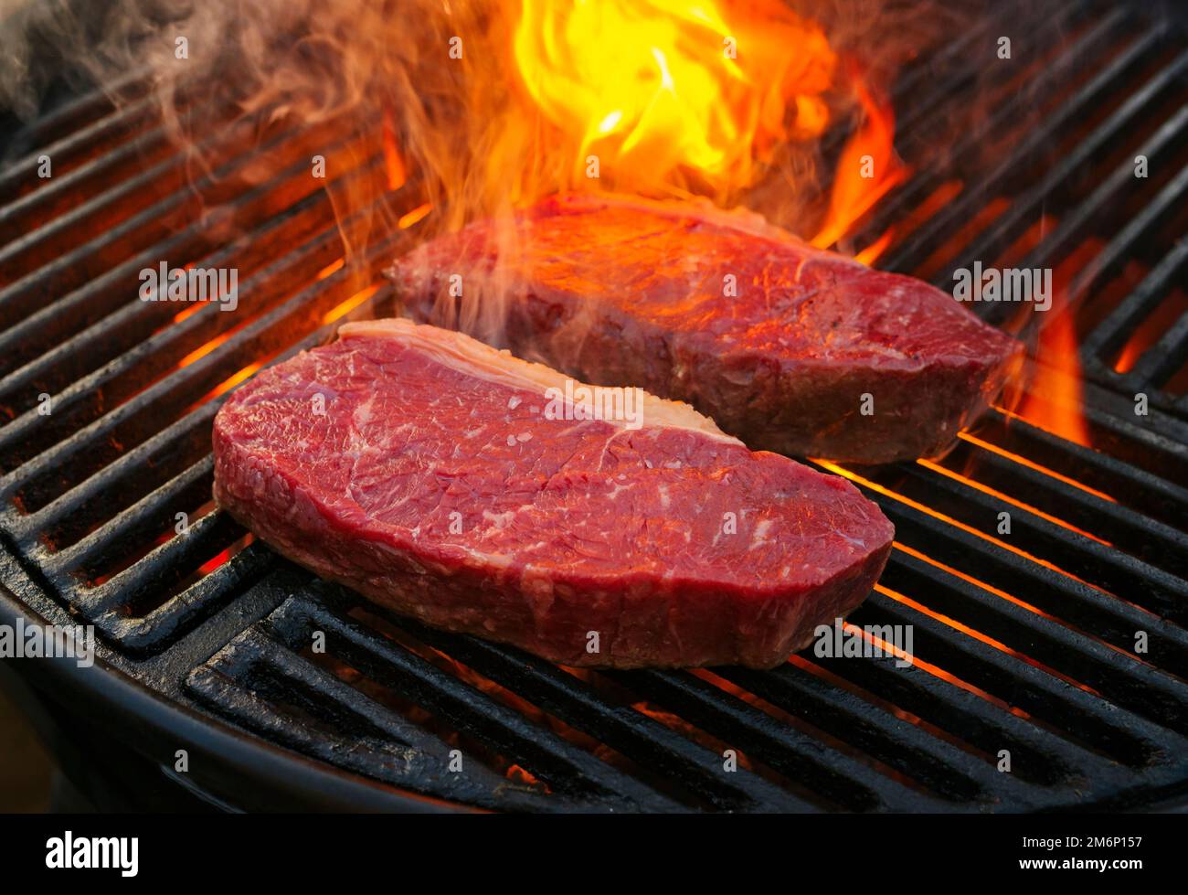 Raw dry aged wagyu roast beef steak grilled as close-up on a charcoal grill  with fire and smoke Stock Photo - Alamy
