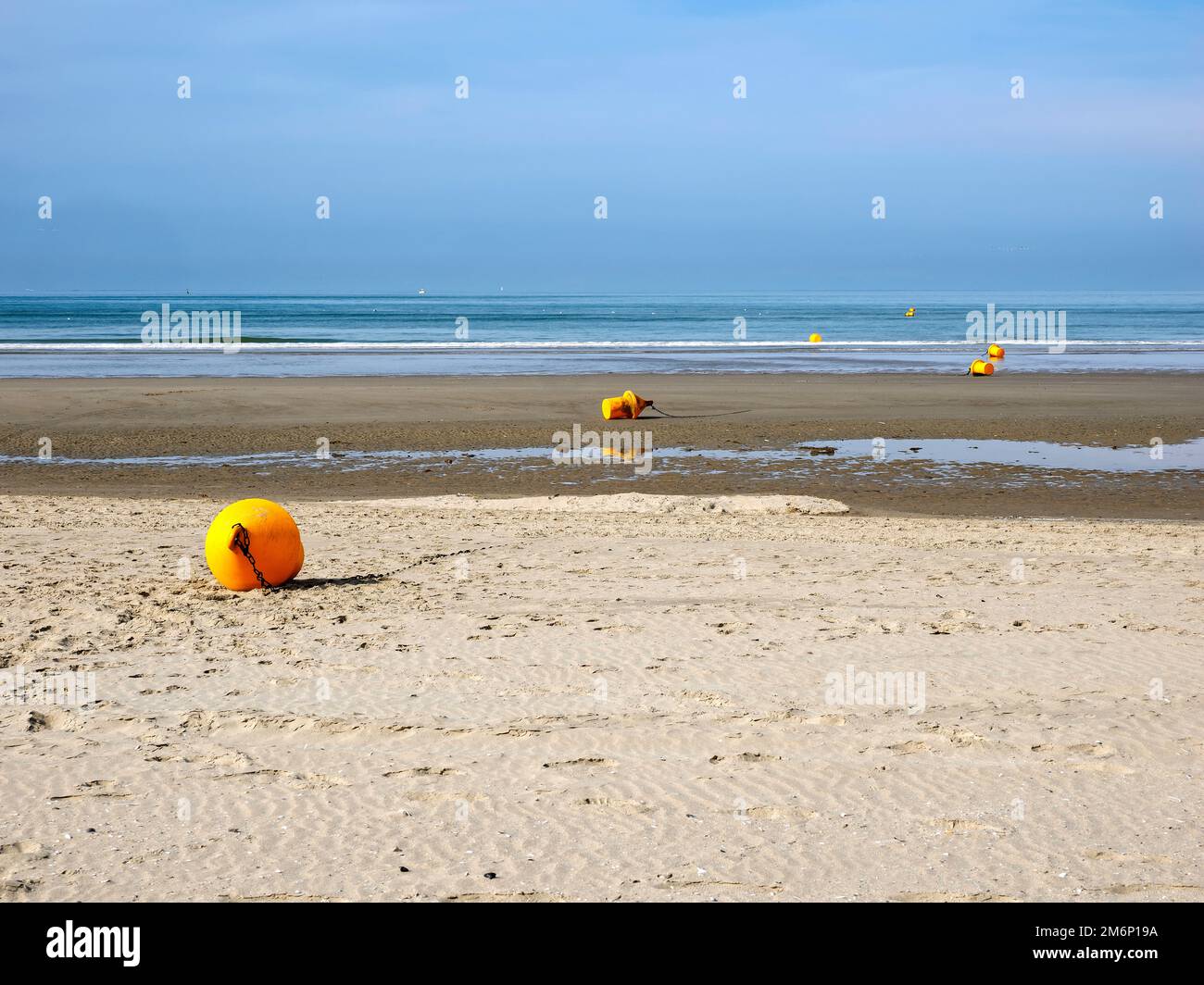 Beach with yellow buoys at low tide of Fort Mahon, a commune in the Somme department in Hauts-de-France in northern France. Stock Photo