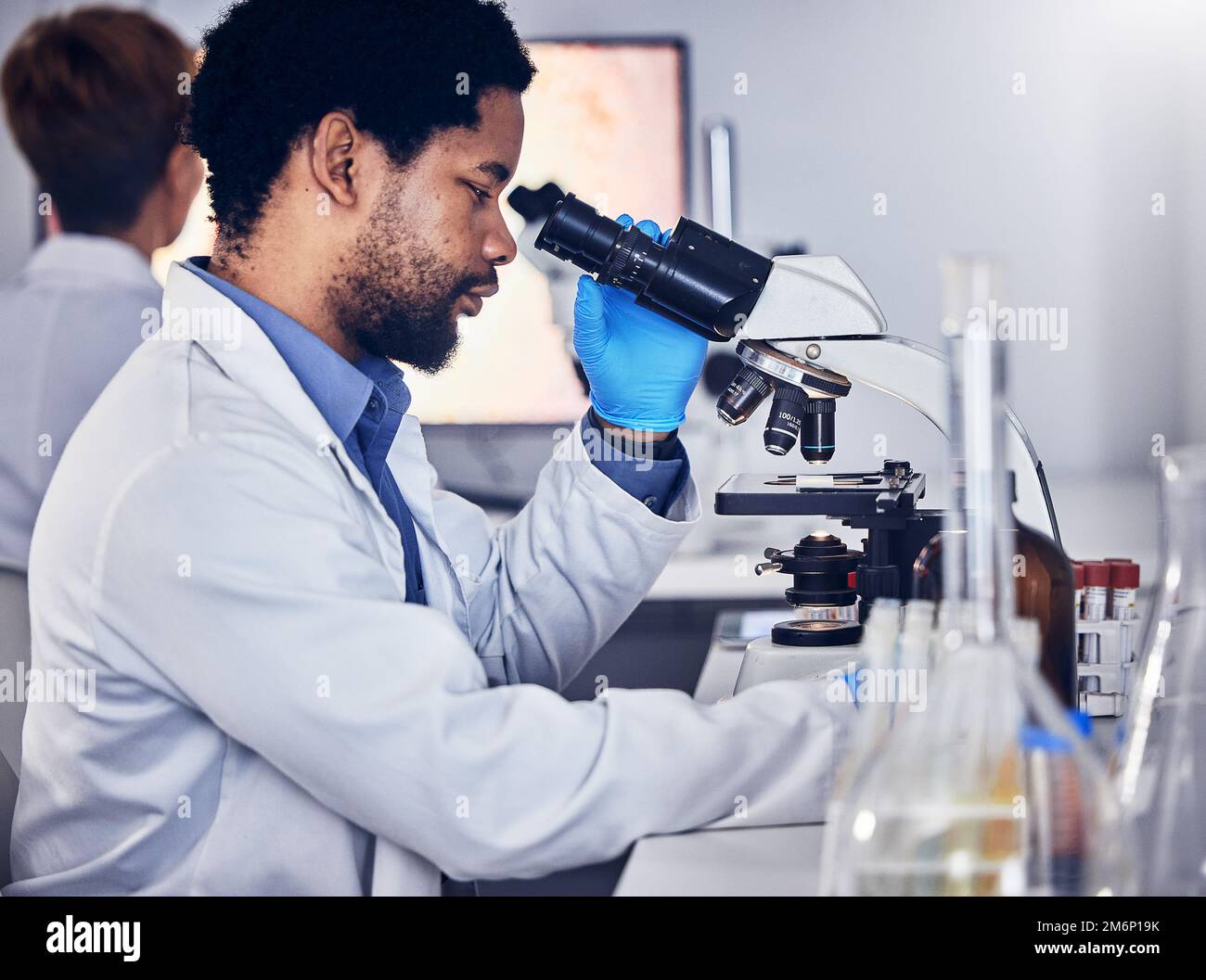 Black man, scientist and microscope with science research in laboratory