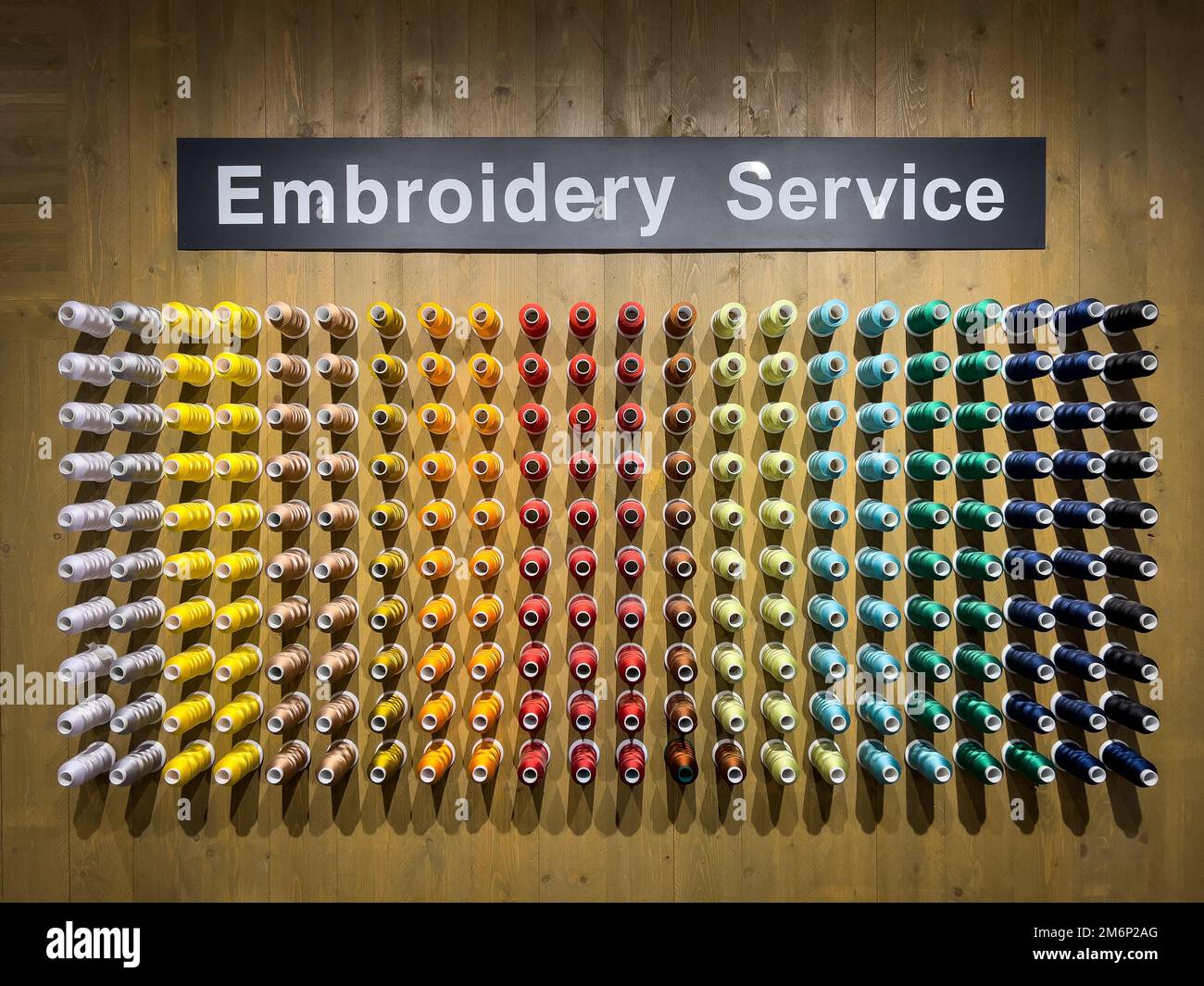Sewing colourful threads display on the wall inside Muji retail store. Stock Photo