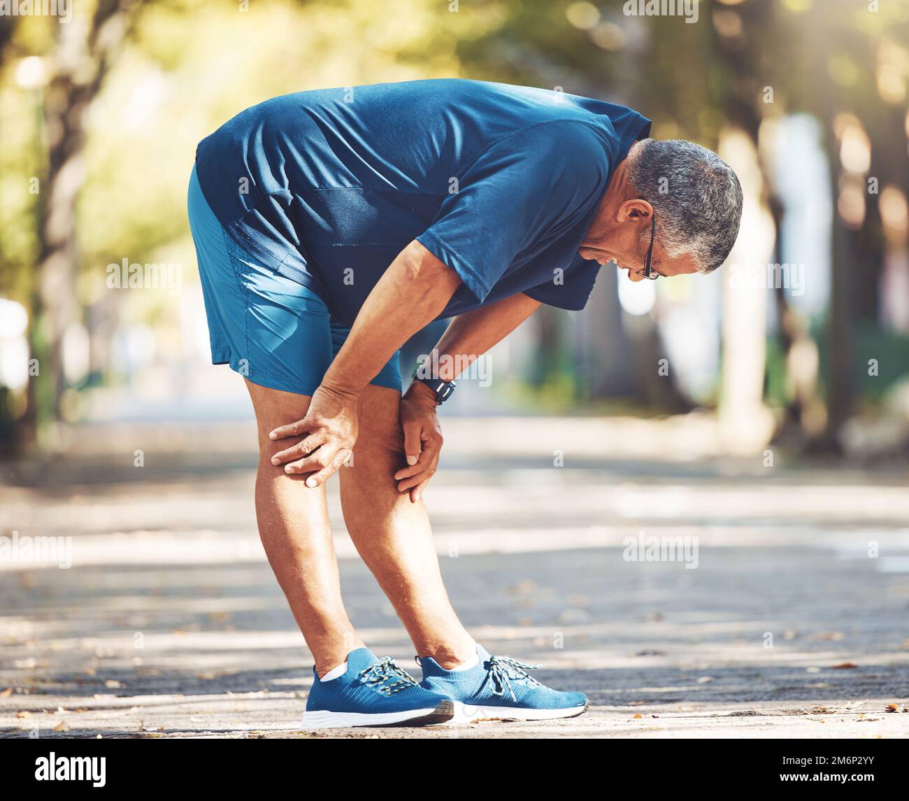 Exercise, senior man and tired outdoor, breathing and balance for wellness, health and retirement. Elderly male, athlete and resting for workout Stock Photo