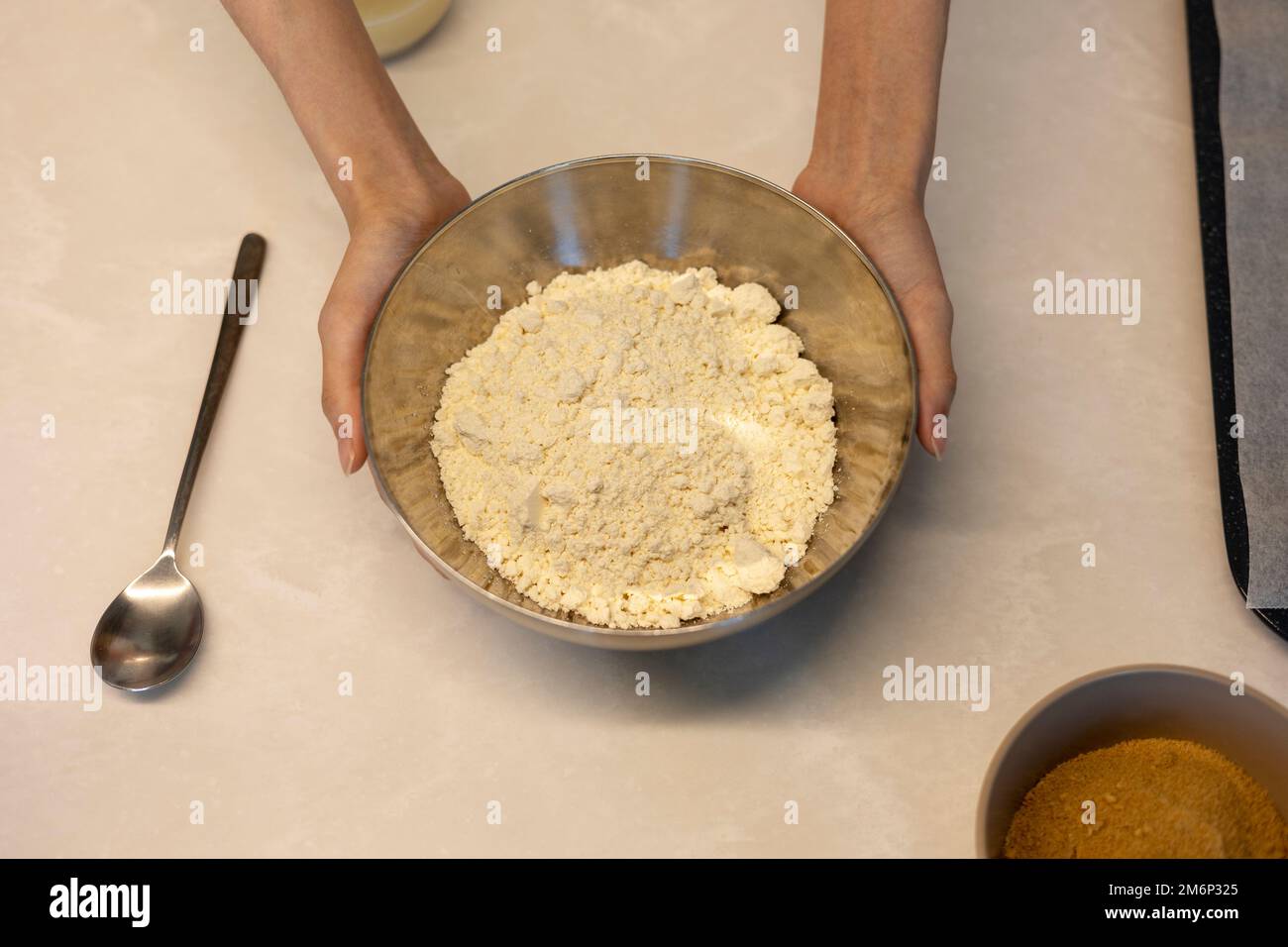 Making cookie bread hotteok dough before baking, hands holding bowl of