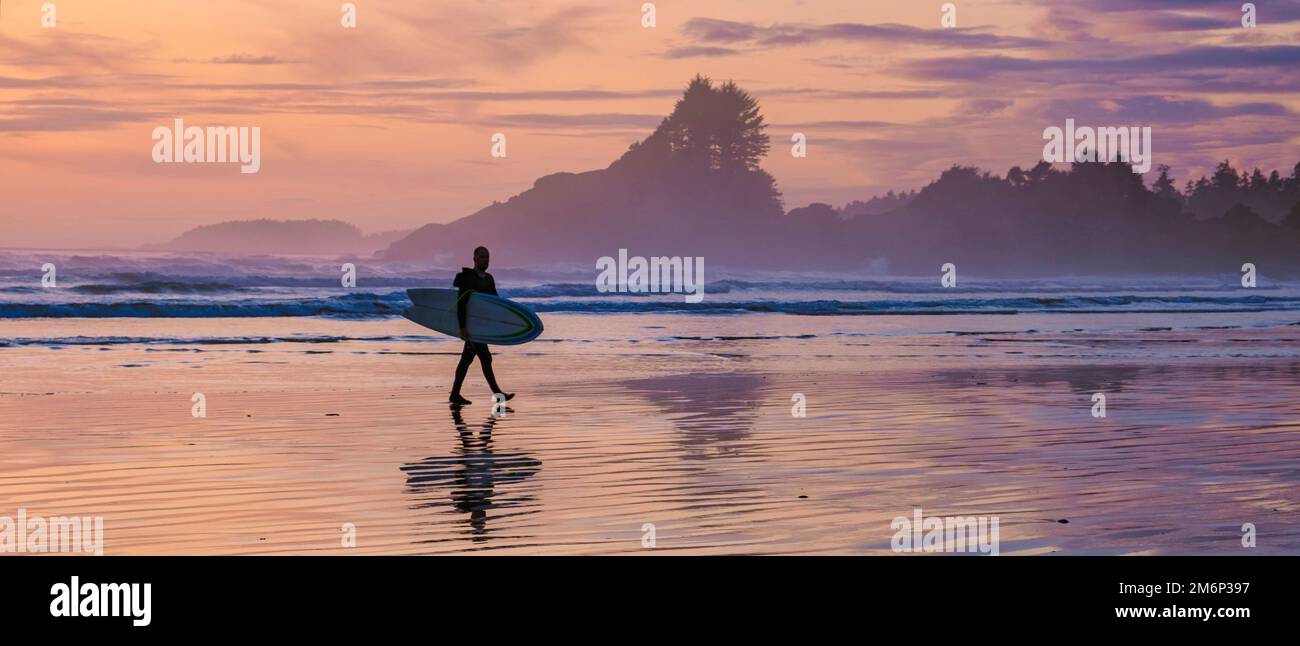Tofino Vancouver Island Pacific rim coast, surfers with board during sunset at the beach Stock Photo