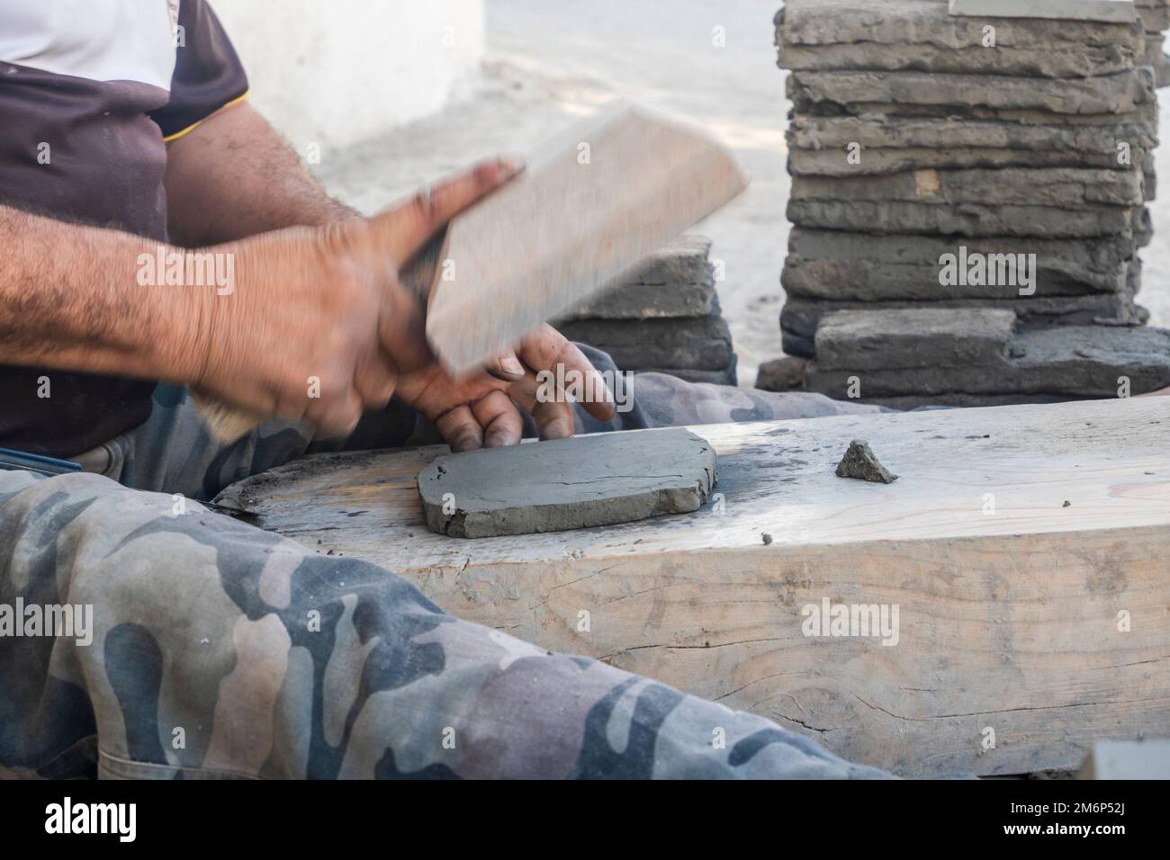 Worker manually forming a clay tile in potter factory in Fez, Morocco, North Africa Stock Photo
