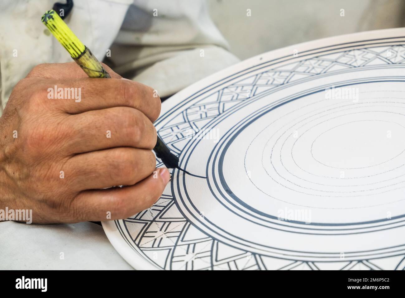 Craftsman painting and decorating ceramic products in pottery factory