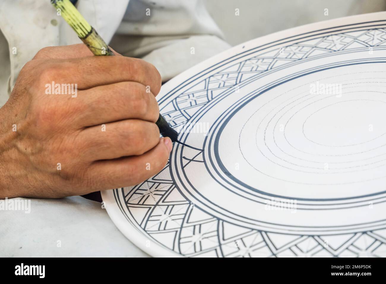 Craftsman painting and decorating ceramic products in pottery factory in Fez, Morocco, North