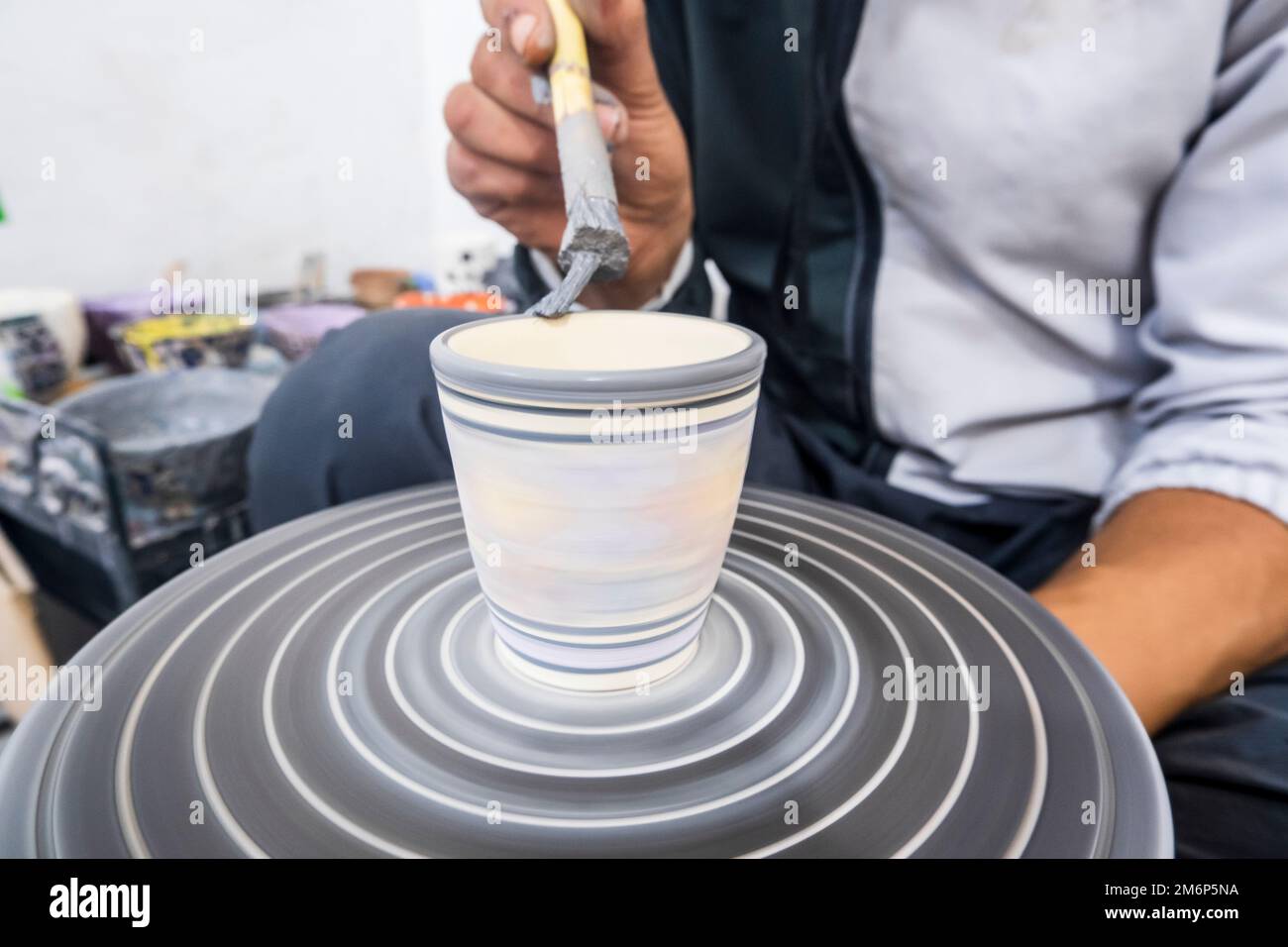 Craftsman painting and decorating ceramic products in pottery factory