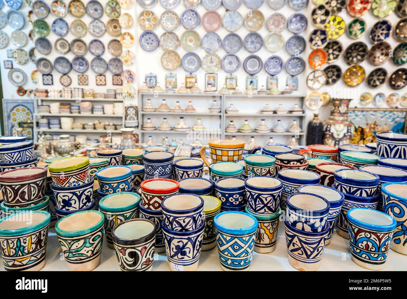 Shelves full of handmade ceramic products in pottery factory in Fez