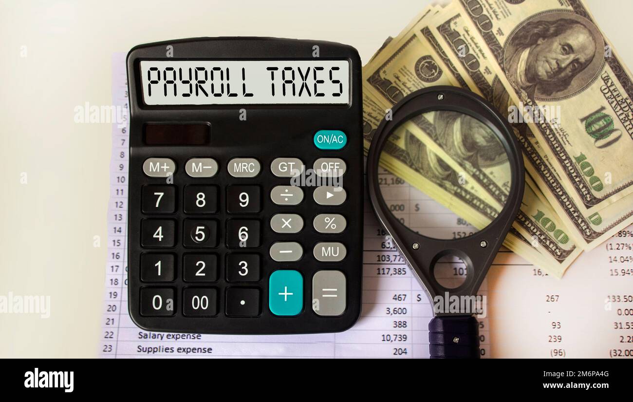 payroll tax words on calculator display, tax forms and dollars Stock Photo