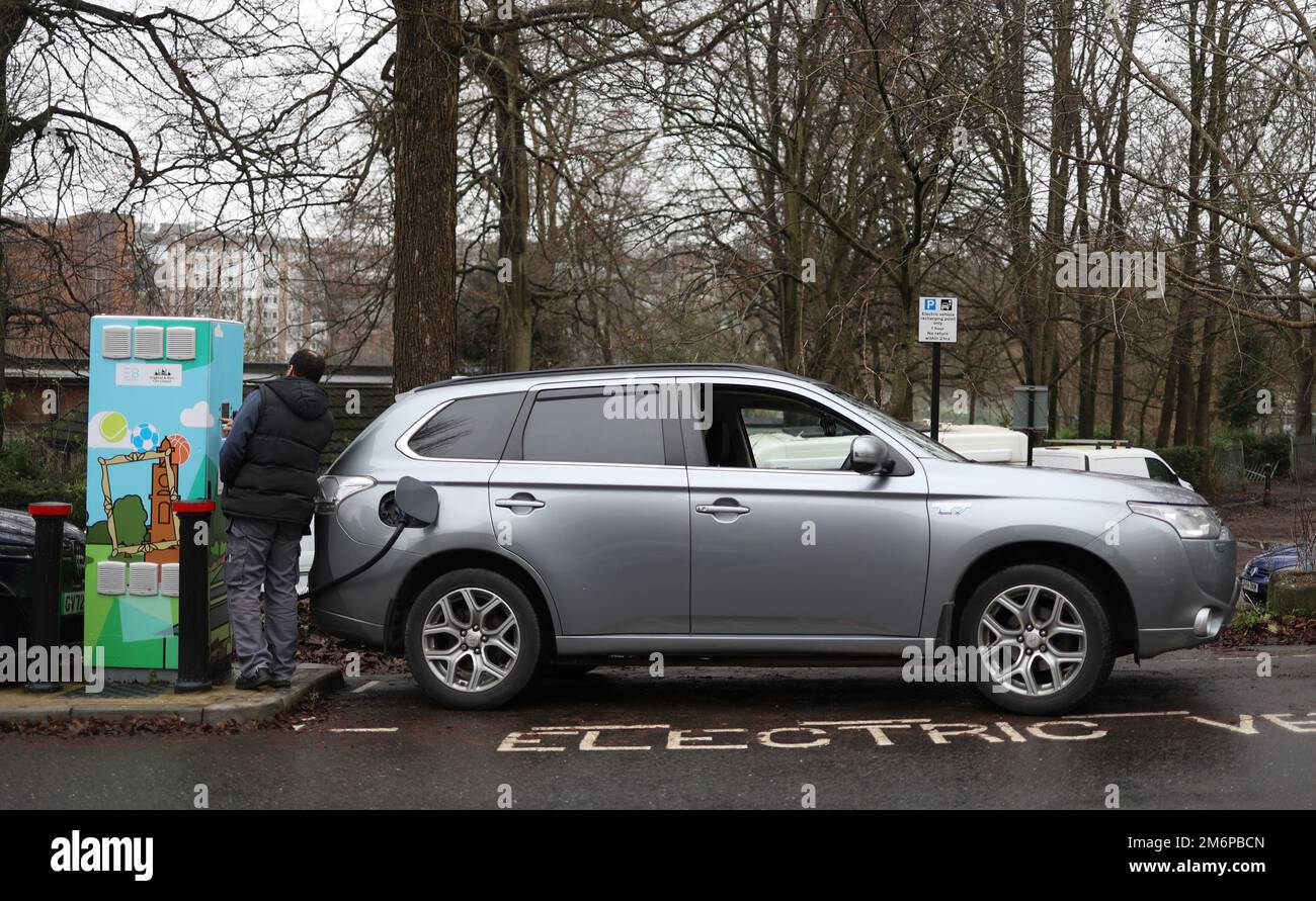 A man charging his Electric Car at a public charging point in Brighton, UK Stock Photo
