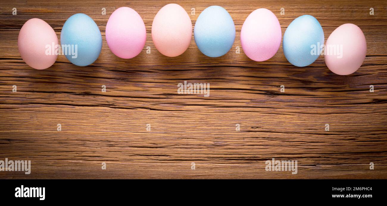 Multicolored eggs on a wooden texture. Easter background Stock Photo
