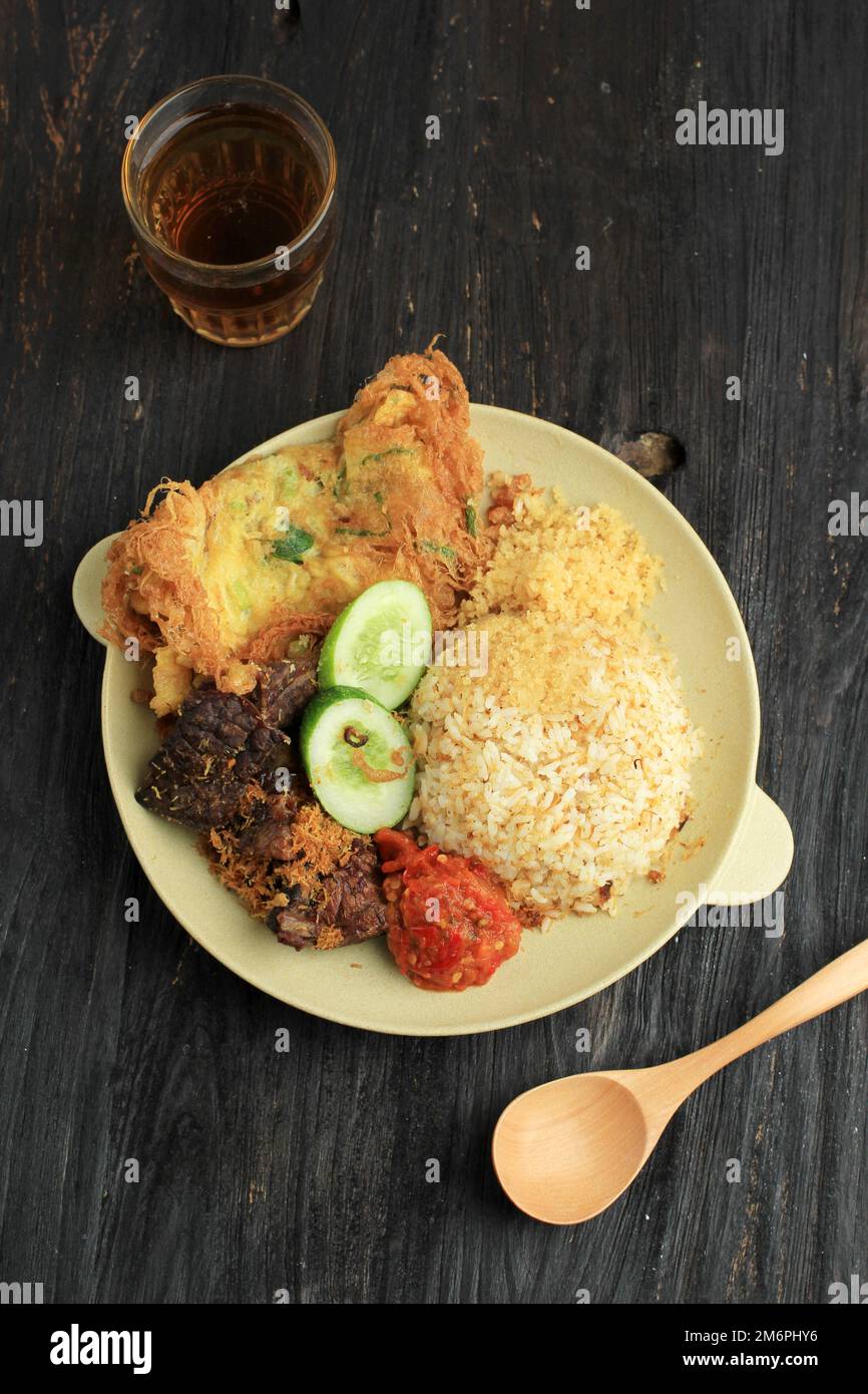 Sego Buk or Nasi Campur Madura, Indonesian Traditional Mixed Rice with Cow Lung, Sambal, and Egg. Top View, Served with Tea Stock Photo