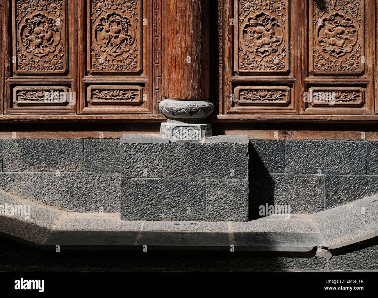 Chinese wooden pillar with stone base detail. Chinese decorative fasade