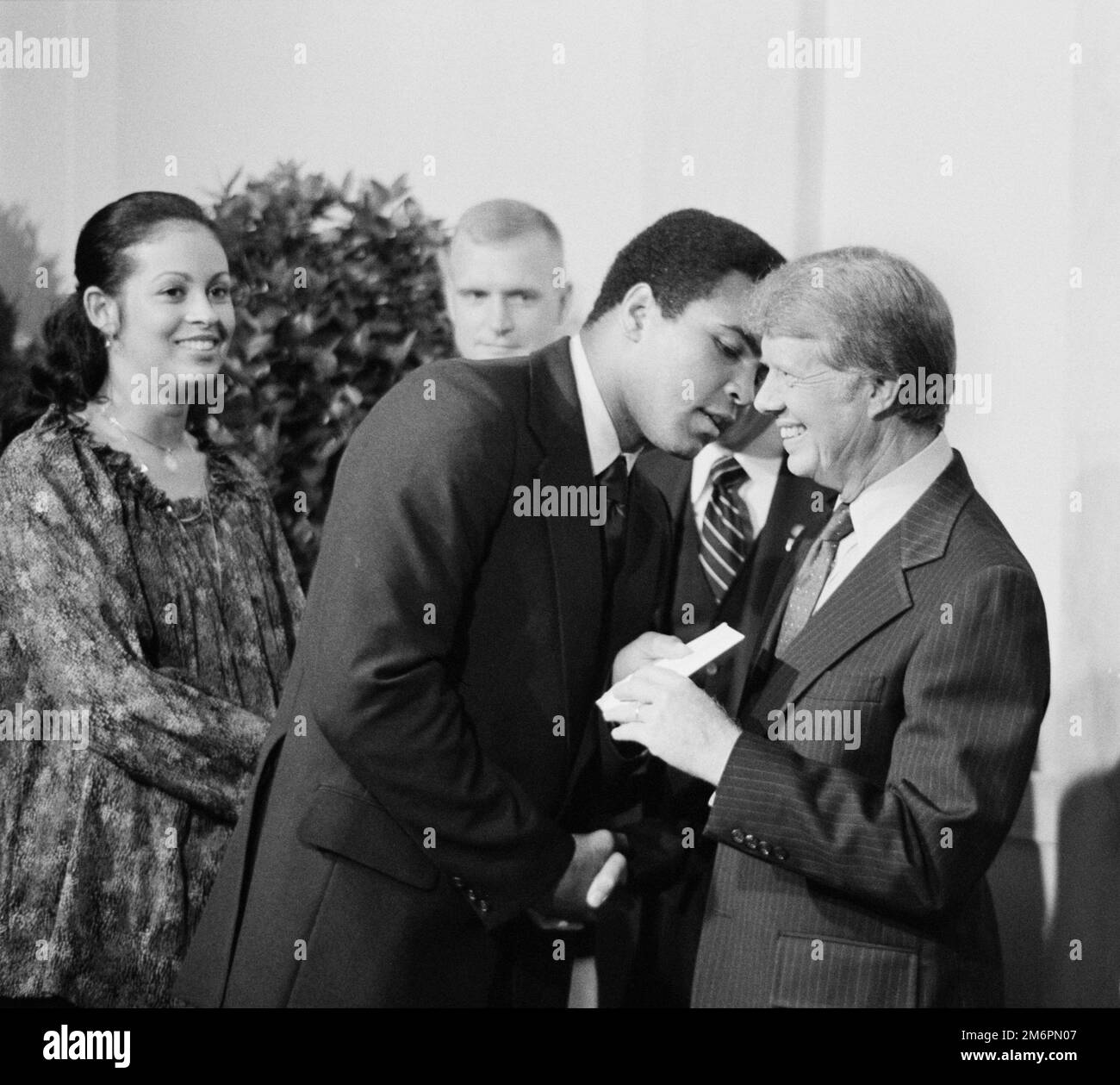 President Jimmy Carter greets Muhammad Ali at a White House dinner, 1977. To the left is the wife of Ali, Veronica Porché Ali. Stock Photo