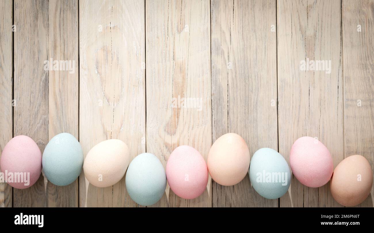 Multicolored eggs on a wooden texture. Easter background Stock Photo