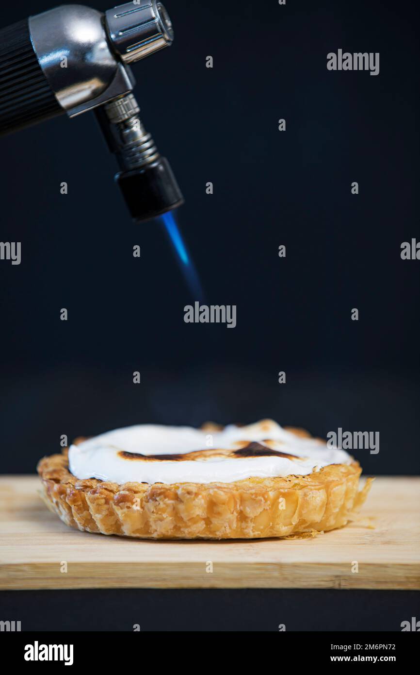A blow torch browning the top of a meringue tart Stock Photo Alamy