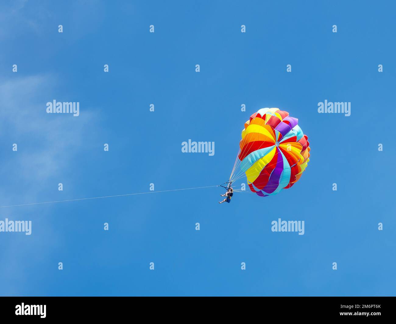 Two tourists are flying on a colored parachute Stock Photo