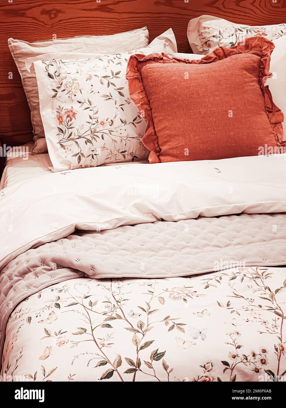 Vintage countryside style bedding with floral pattern on wooden bed in