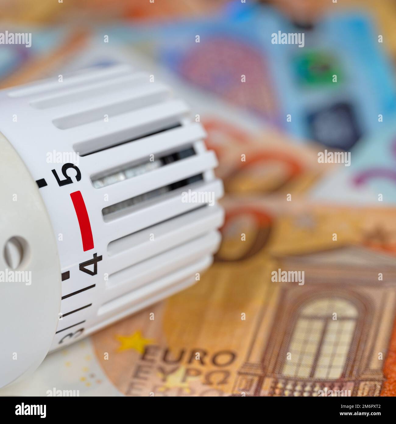 Thermostat in front of banknotes, symbolic of heating costs Stock Photo
