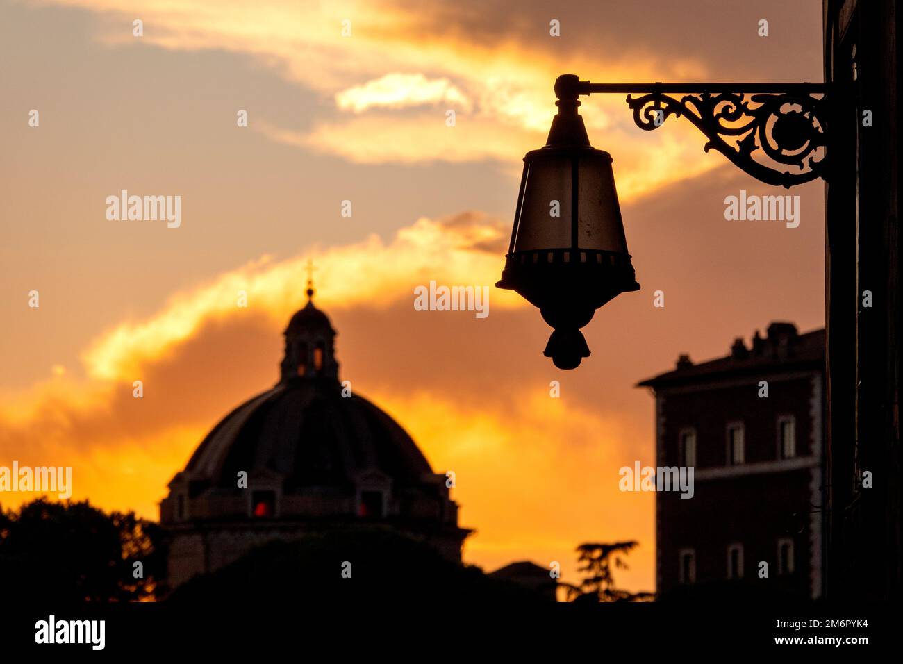 Silhouette of a roman street lamp in front of the dome of Santa Maria di Loreto, Rome, Italy Stock Photo