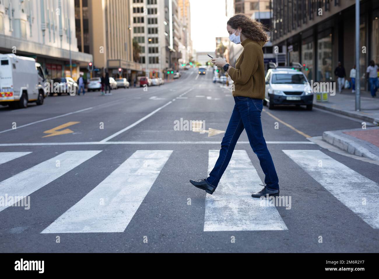 Caucasian woman wearing a protective mask and walking in the streets ...