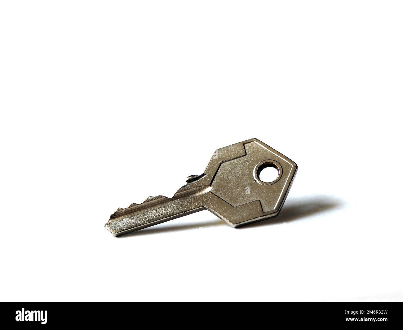 Isolated metal padlock key on white background. Stock Photo