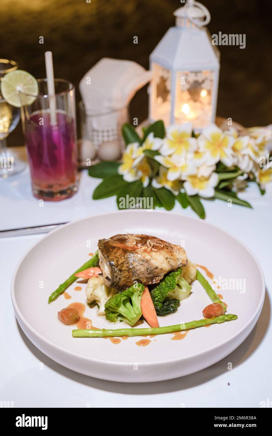 Seabass on a plate during Romantic dinner on beach of Huahin Thailand, Stock Photo